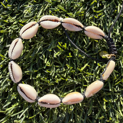 Necklace with cowrie shells on a grass background