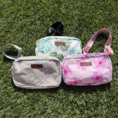 Three bags with floral and leaf patterns on a grassy surface
