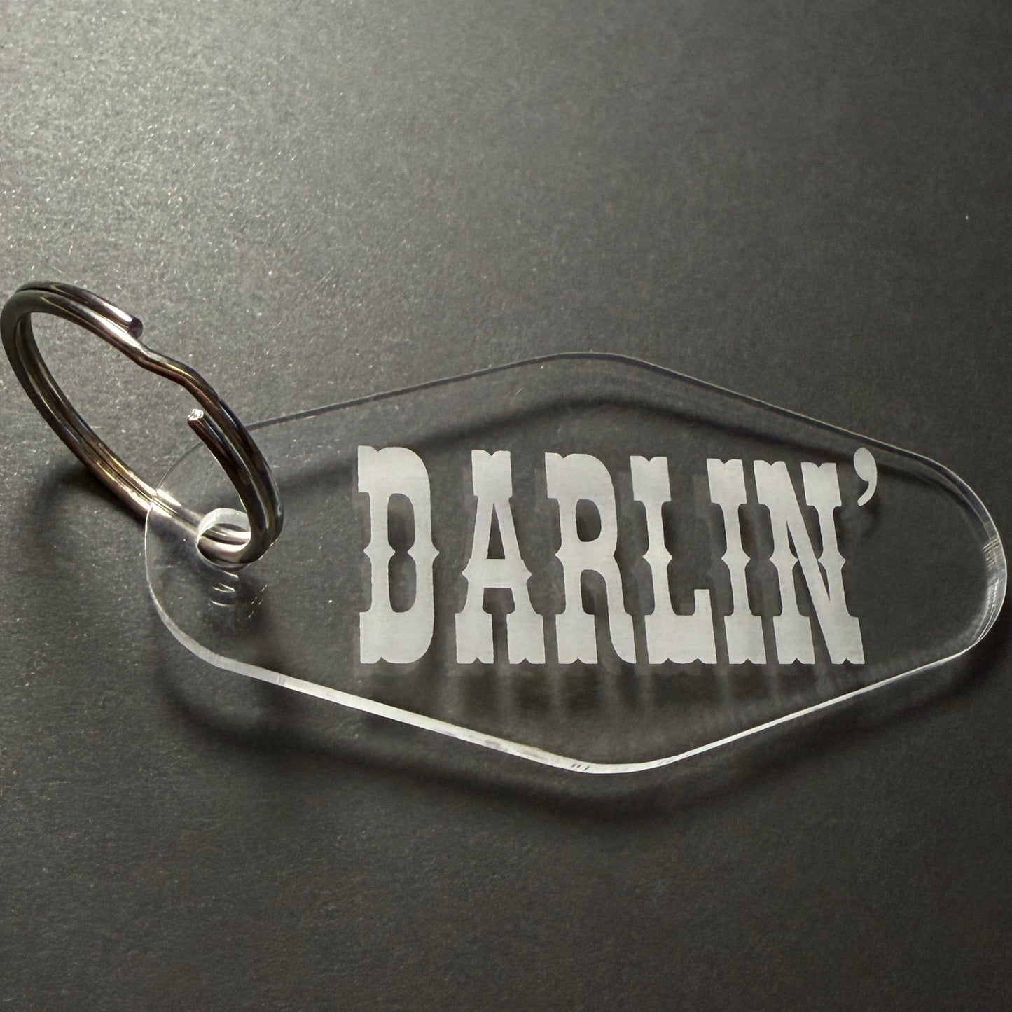 Clear keychain with DARLIN' branding on a dark background