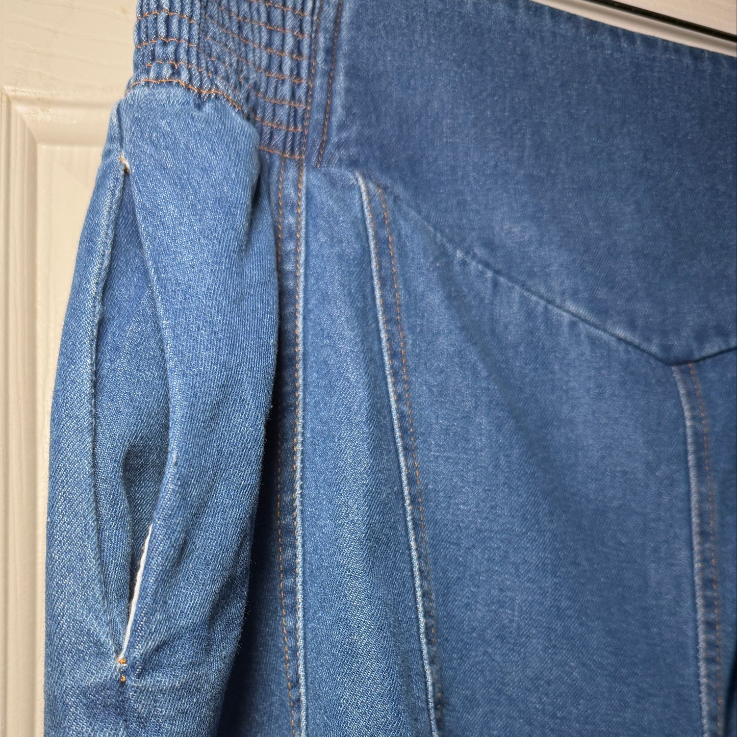 Close-up of blue jeans with a beige background