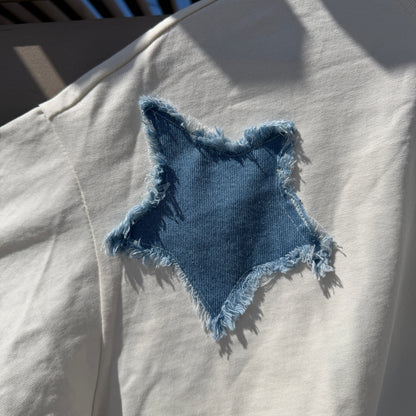 Blue denim patch on a white shirt with sunlight casting shadows