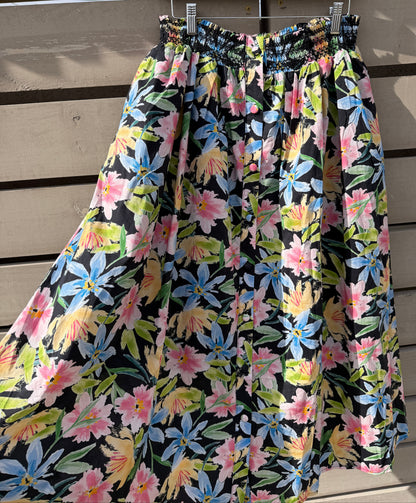 Floral-patterned fabric on a wooden rod against a wooden background