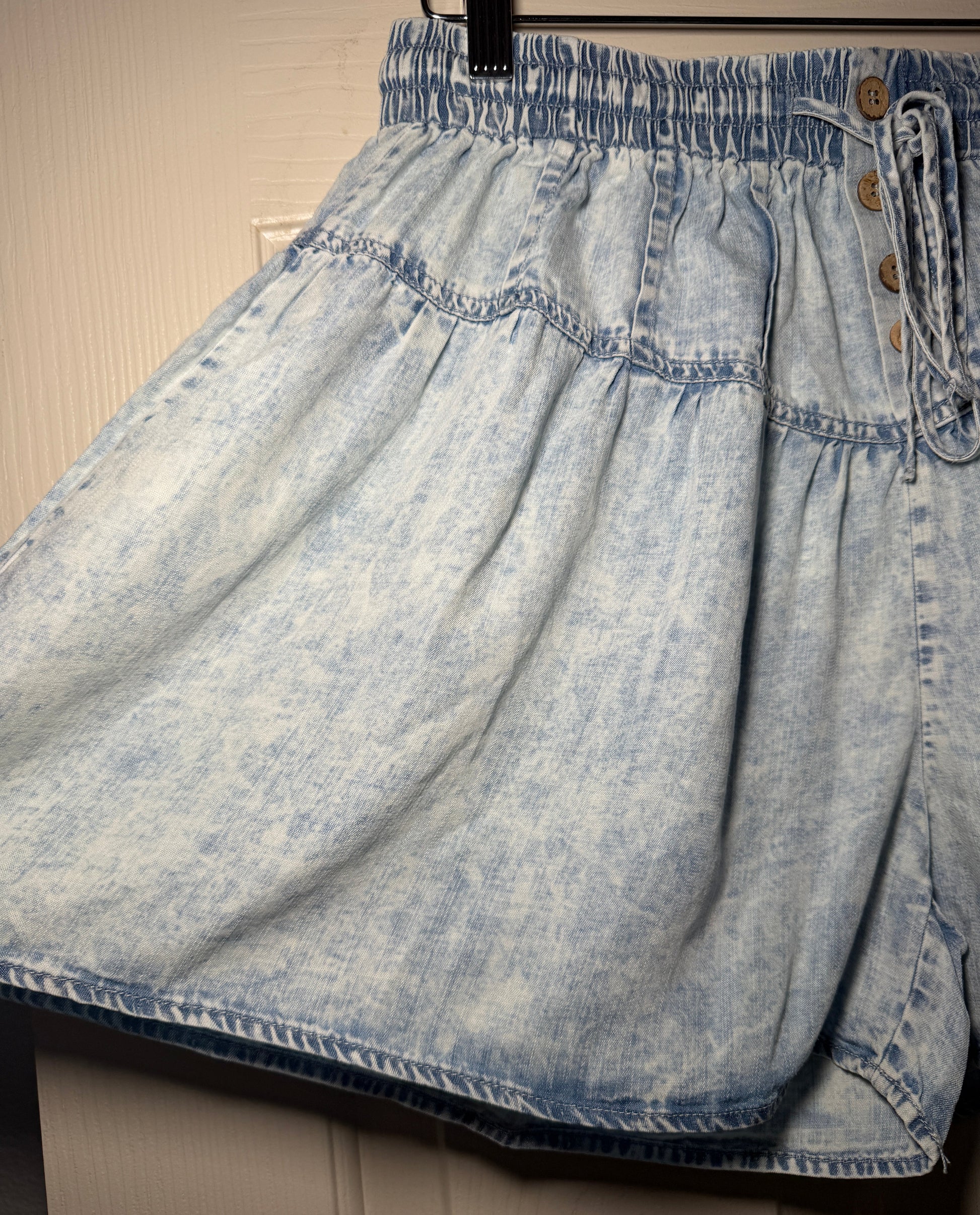Light blue denim shorts on a wooden surface