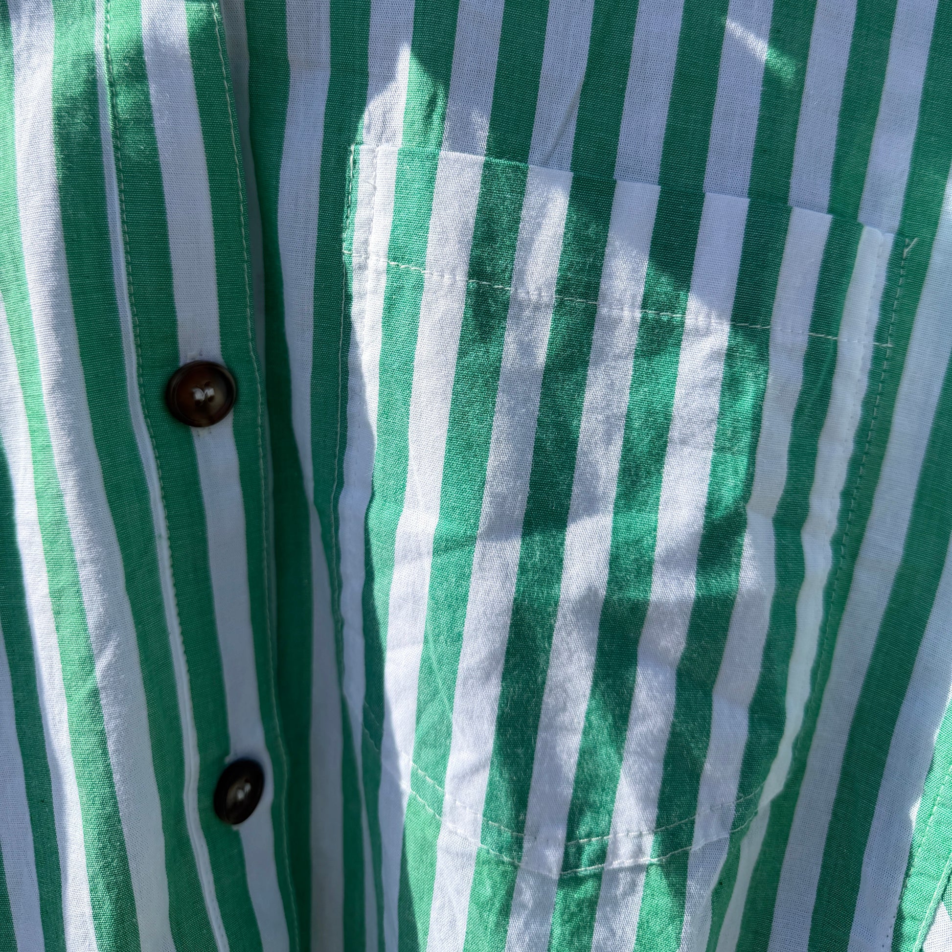Close-up of a green and white striped shirt with buttons.