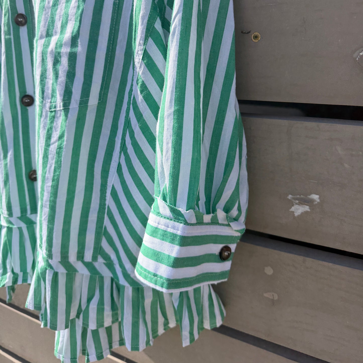 Green and white striped shirt on a wooden surface
