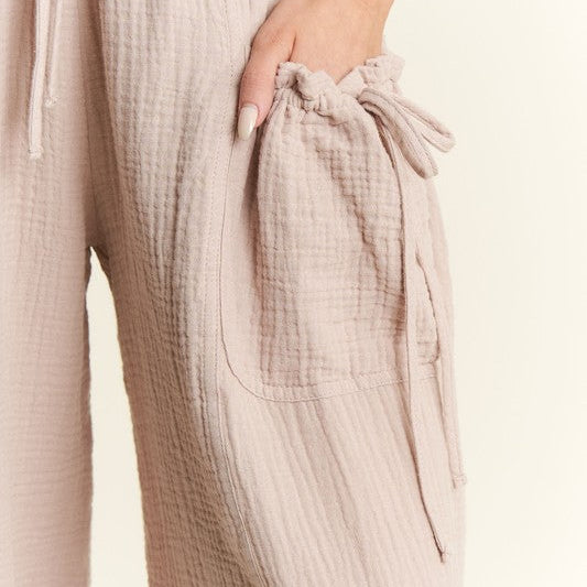 Beige textured pants with a drawstring waist on a light background