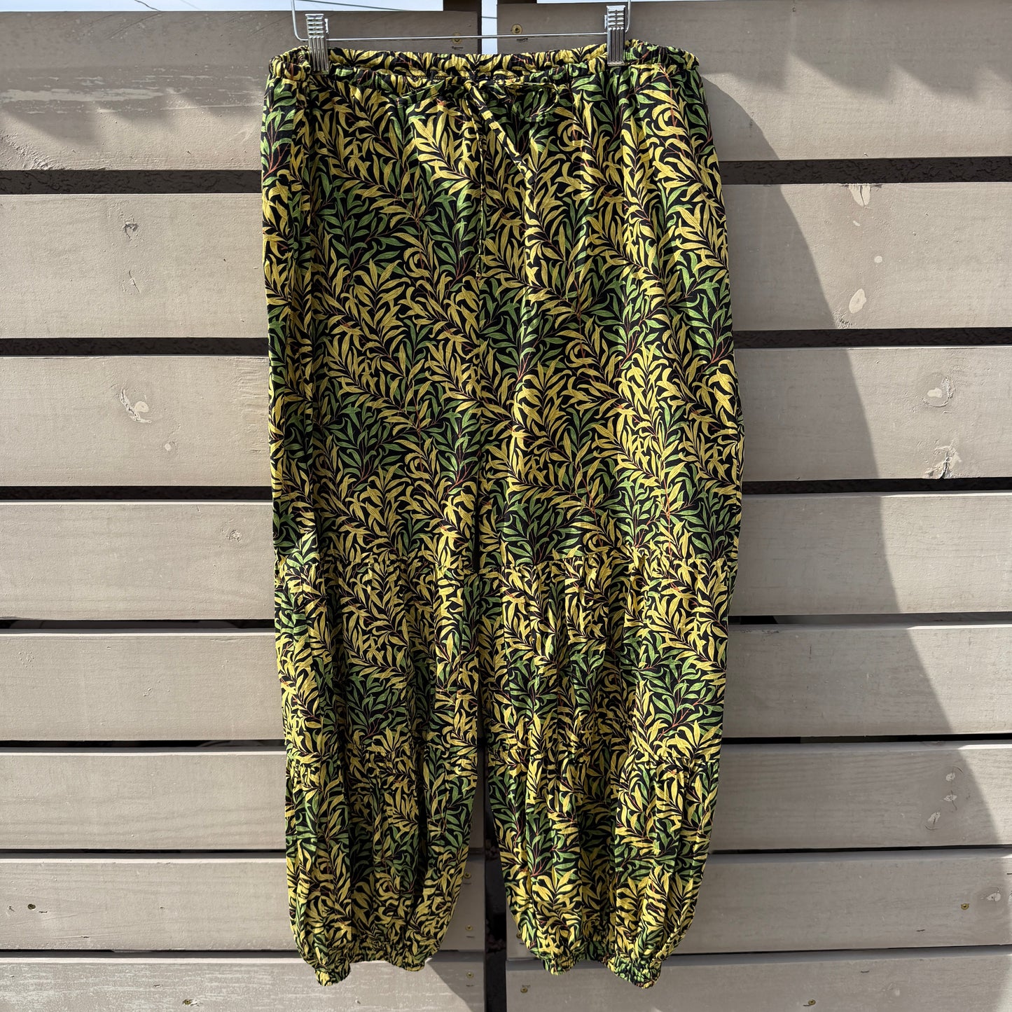 Folded green and yellow patterned fabric on a wooden surface
