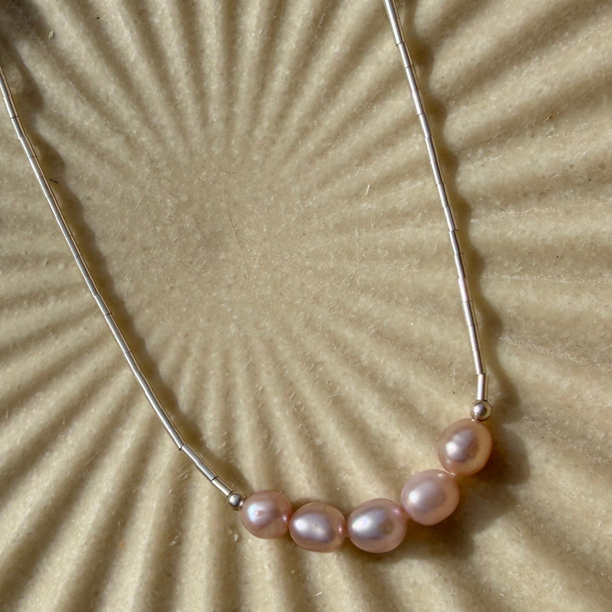 Pearl necklace on a textured beige background