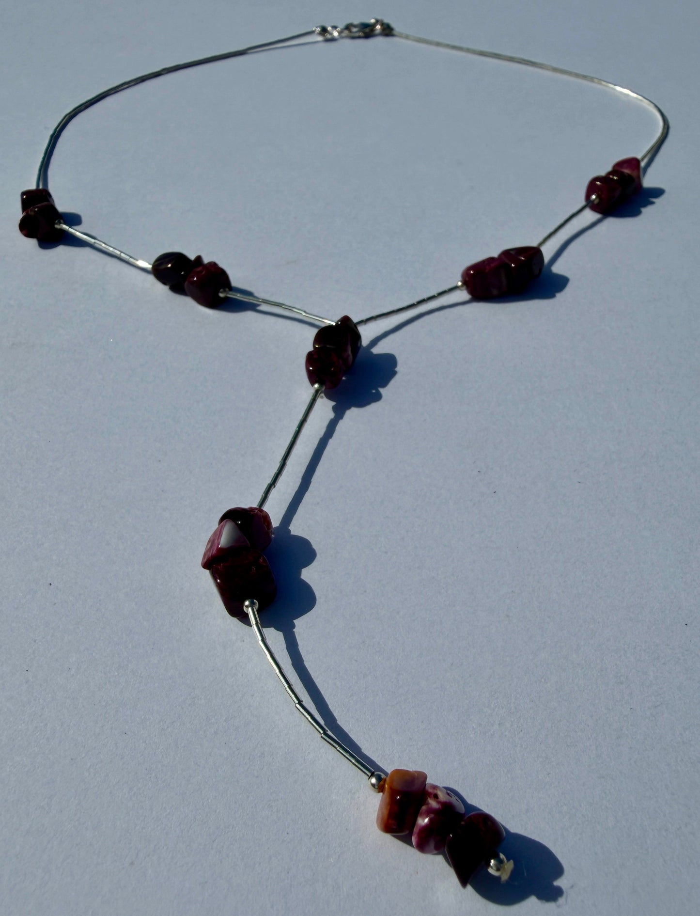 Necklace with purple spiny chip beads on a light gray background