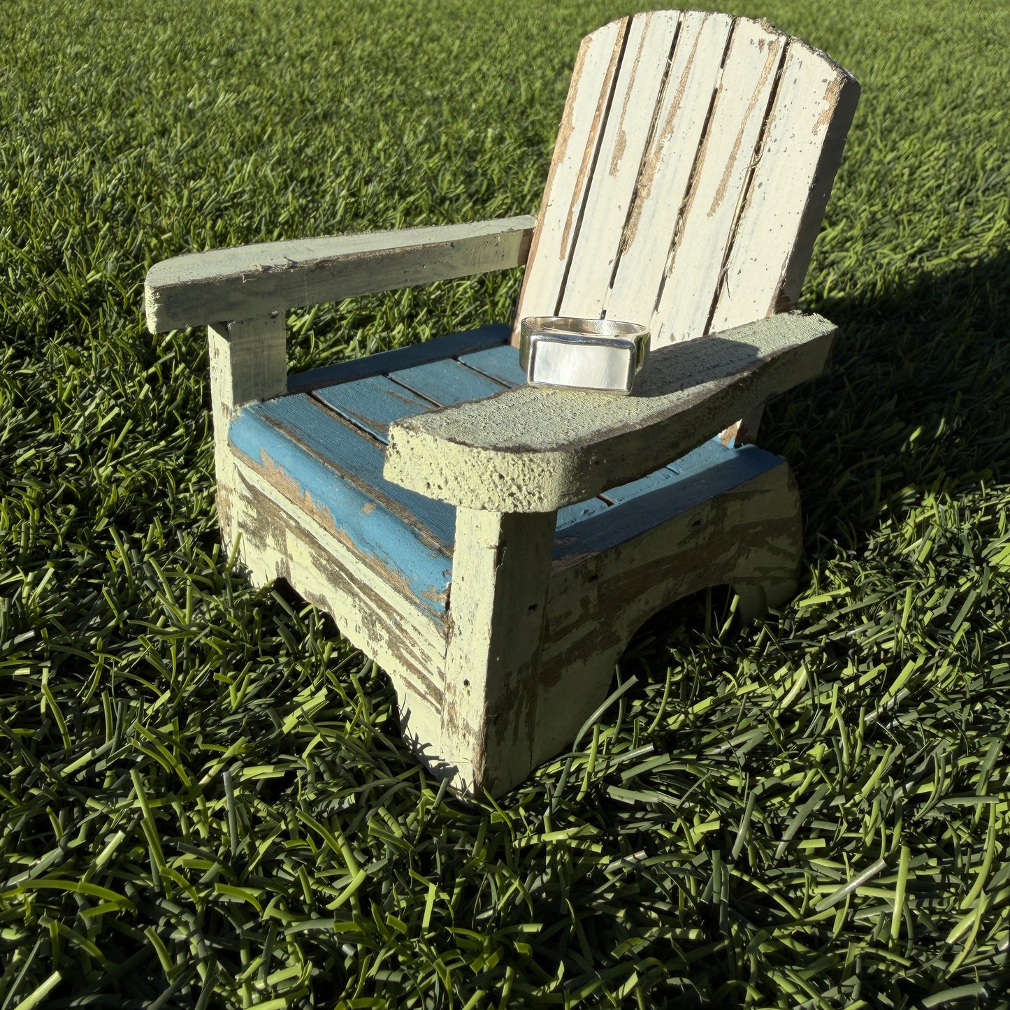 Wooden bench on grass with a ring on the arm rest