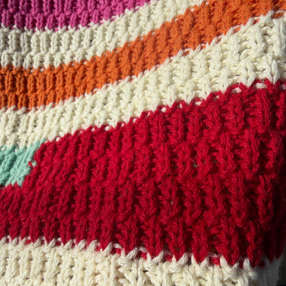 Close-up of a knitted fabric with multicolor stripes.