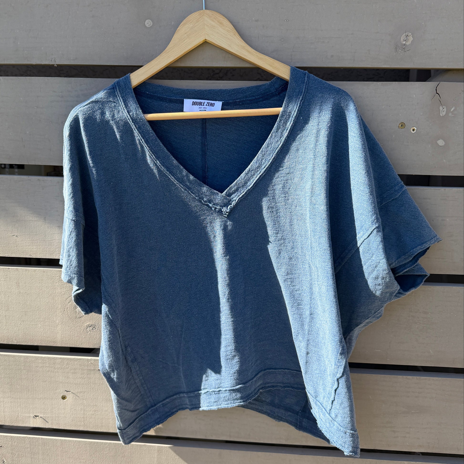 Blue sleeveless top on a wooden surface