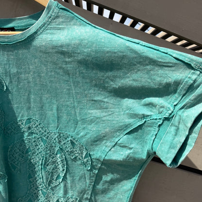 Green tank top with a logo on a wooden surface