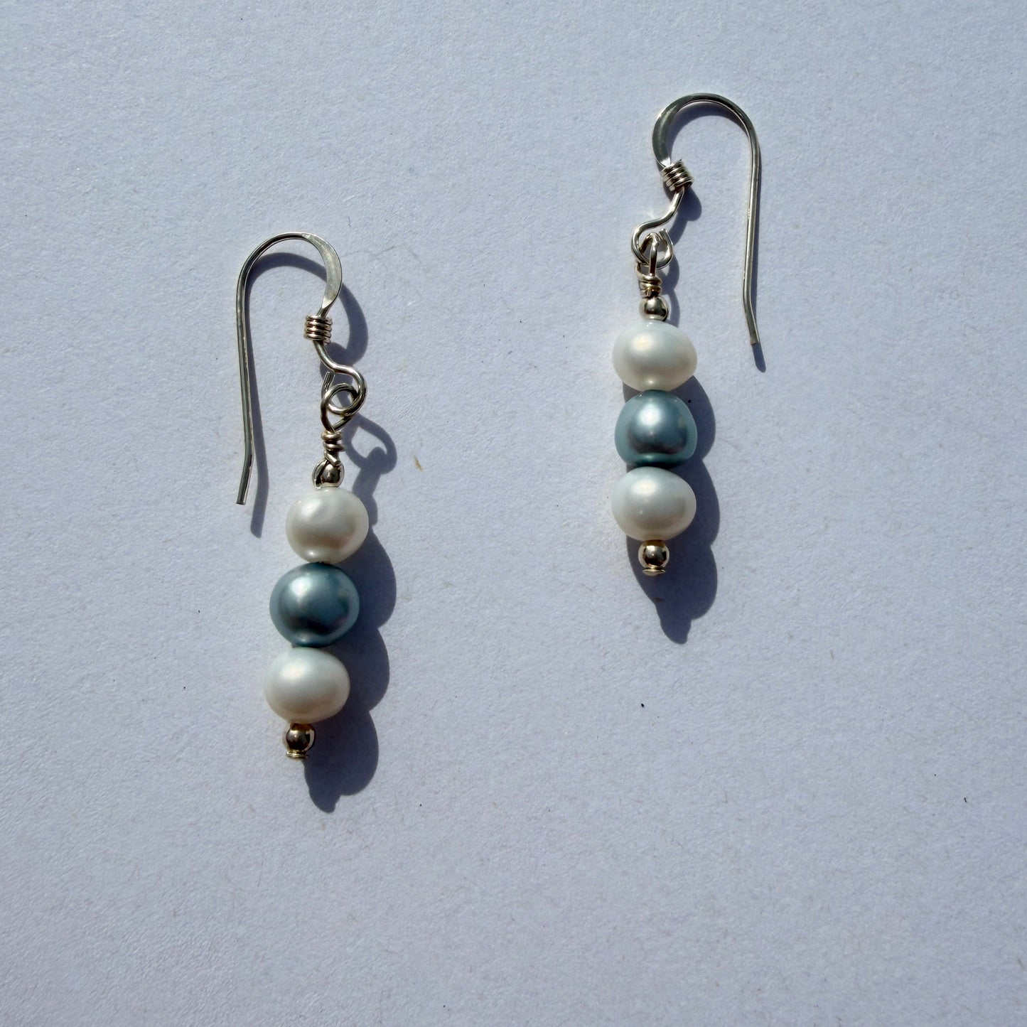 Pair of pearl earrings on a light gray background