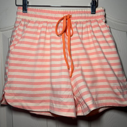 Pink and white striped drawstring bag on a hanger against a neutral background