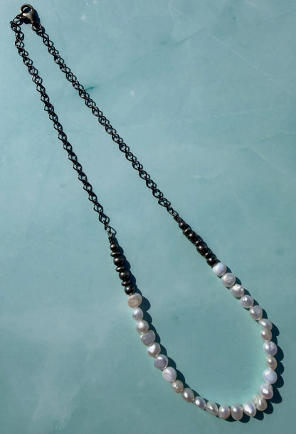 Necklace with white pearls on a light blue background