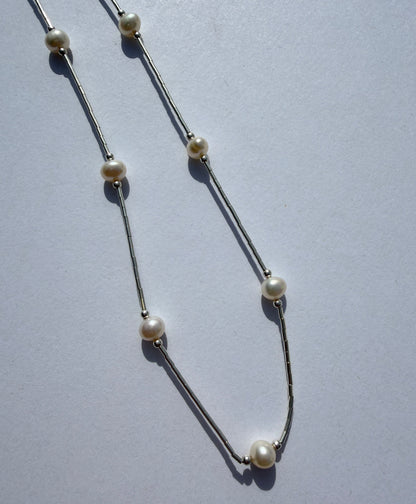 Pearl necklace on a light gray background