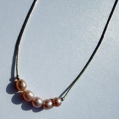 Pearl necklace on a light gray background