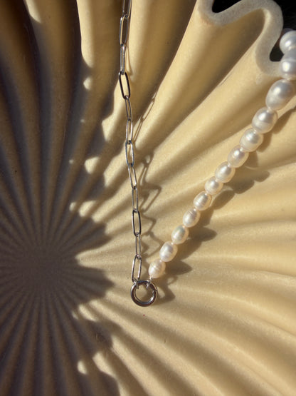 Pearl necklace on a textured beige background