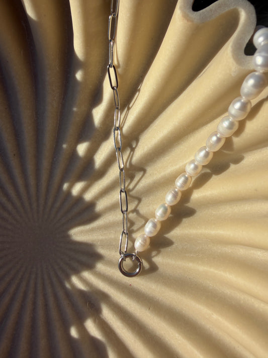 Pearl necklace on a textured beige background