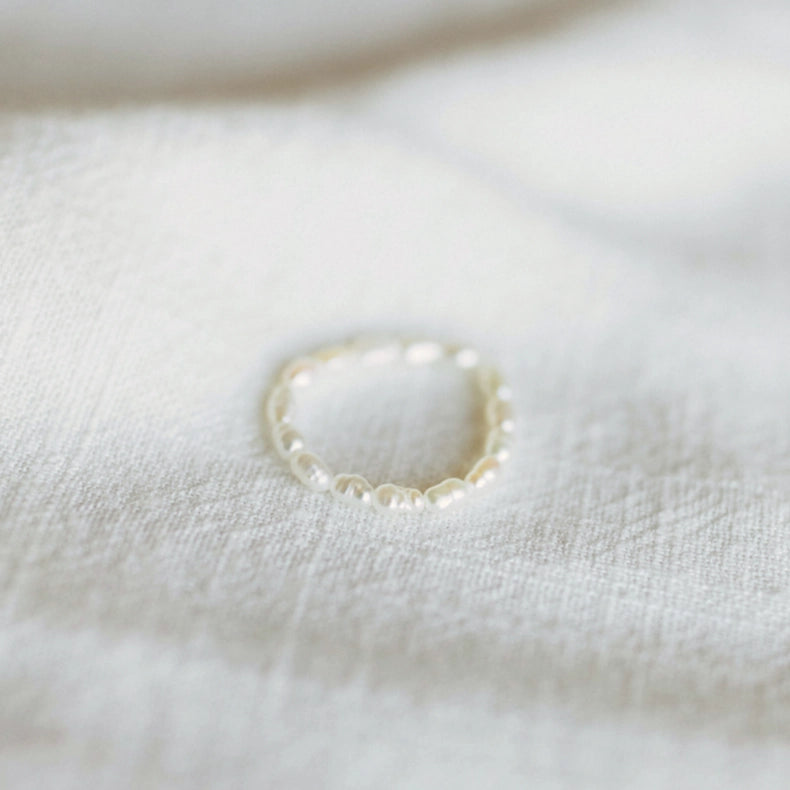 Pearl ring on a white fabric background