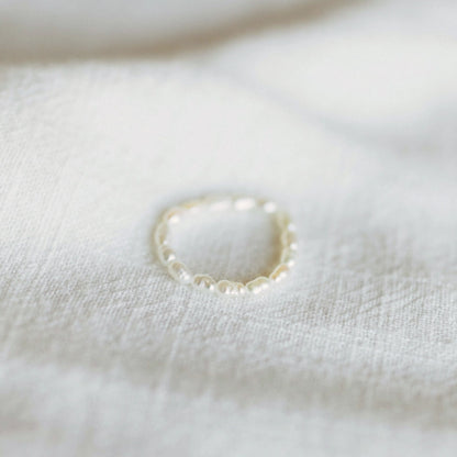 Pearl ring on a white fabric background