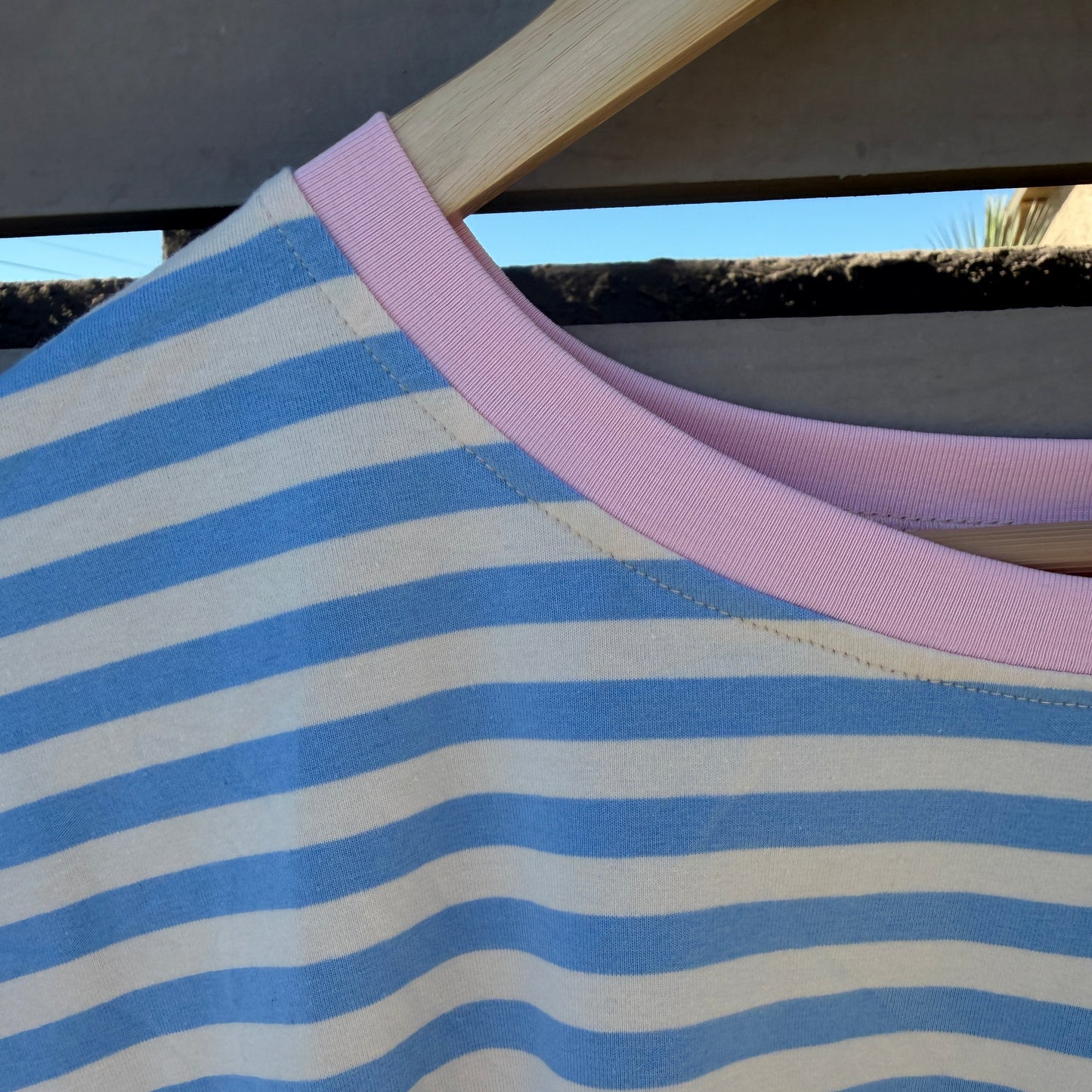 Close-up of a blue and white striped fabric with a pink trim.