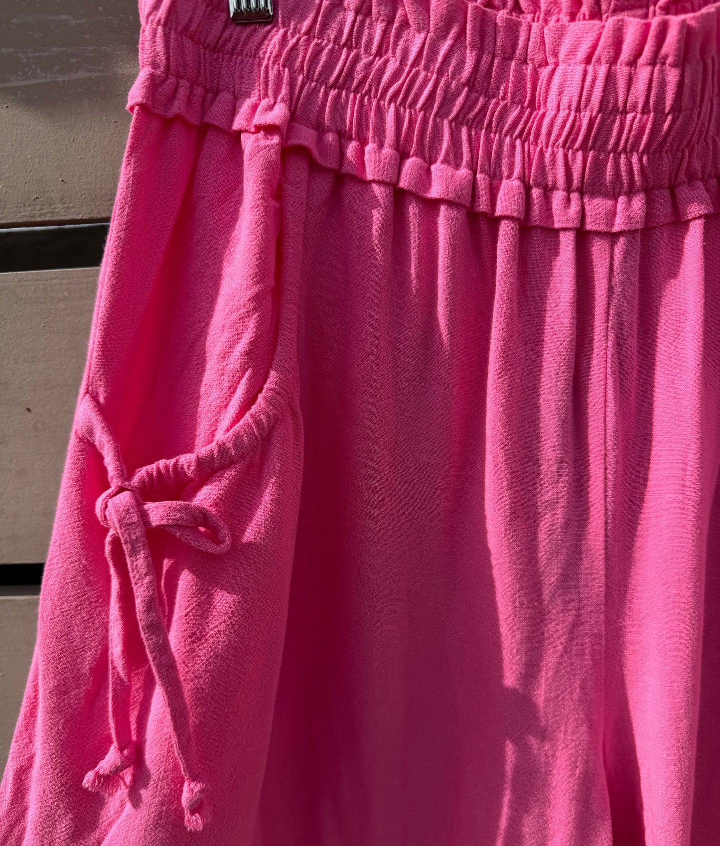 Close-up of pink pants with a drawstring on a neutral background