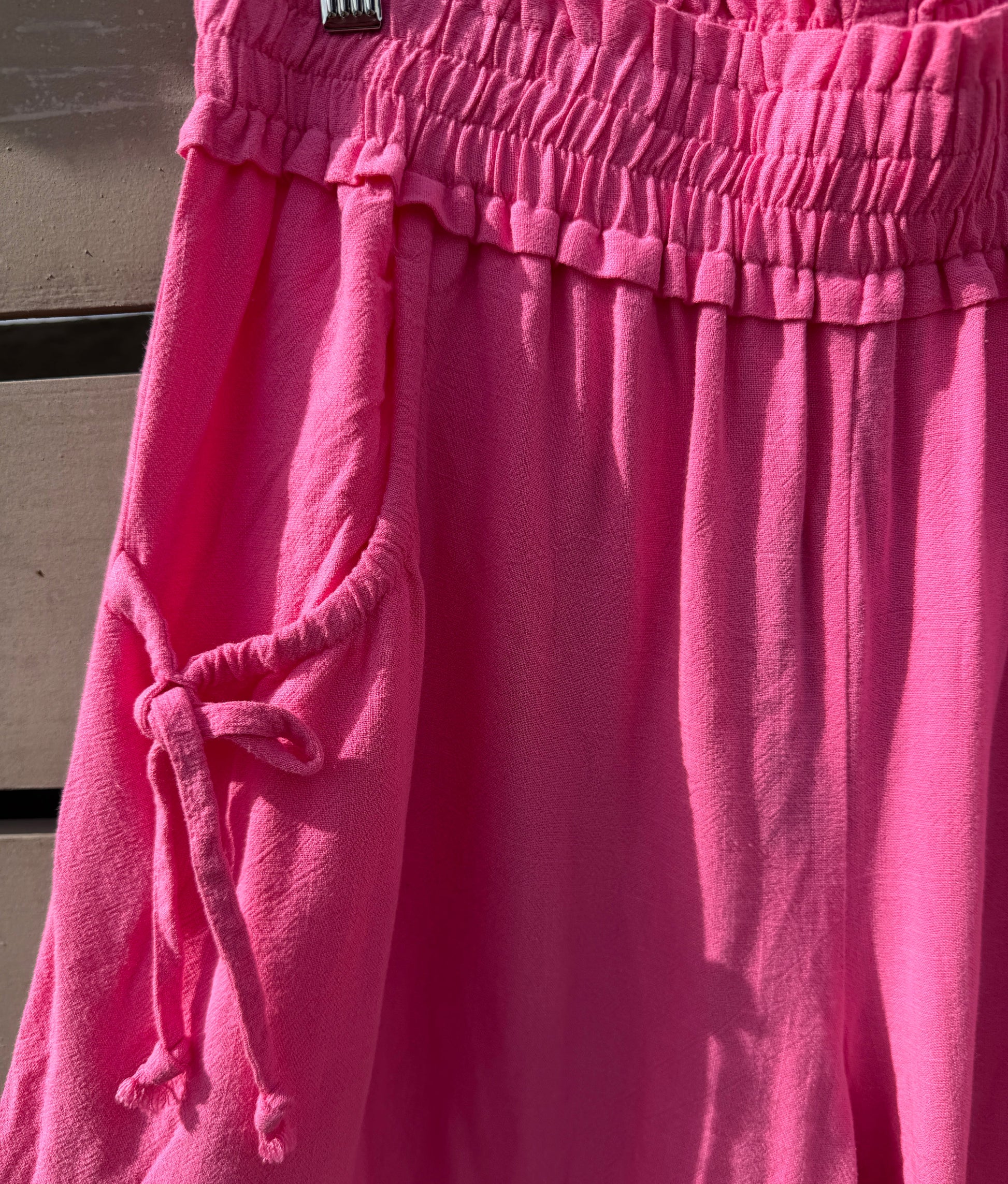 Close-up of pink pants with a drawstring on a neutral background