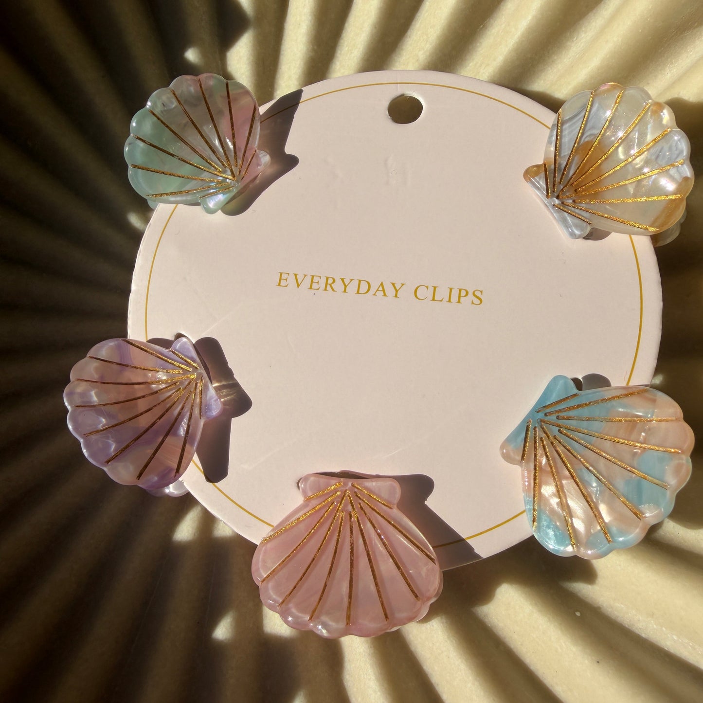 Decorative clip set with shell designs on a beige background