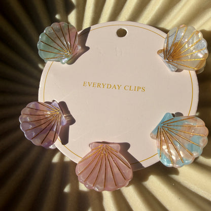 Decorative clip set with shell designs on a beige background