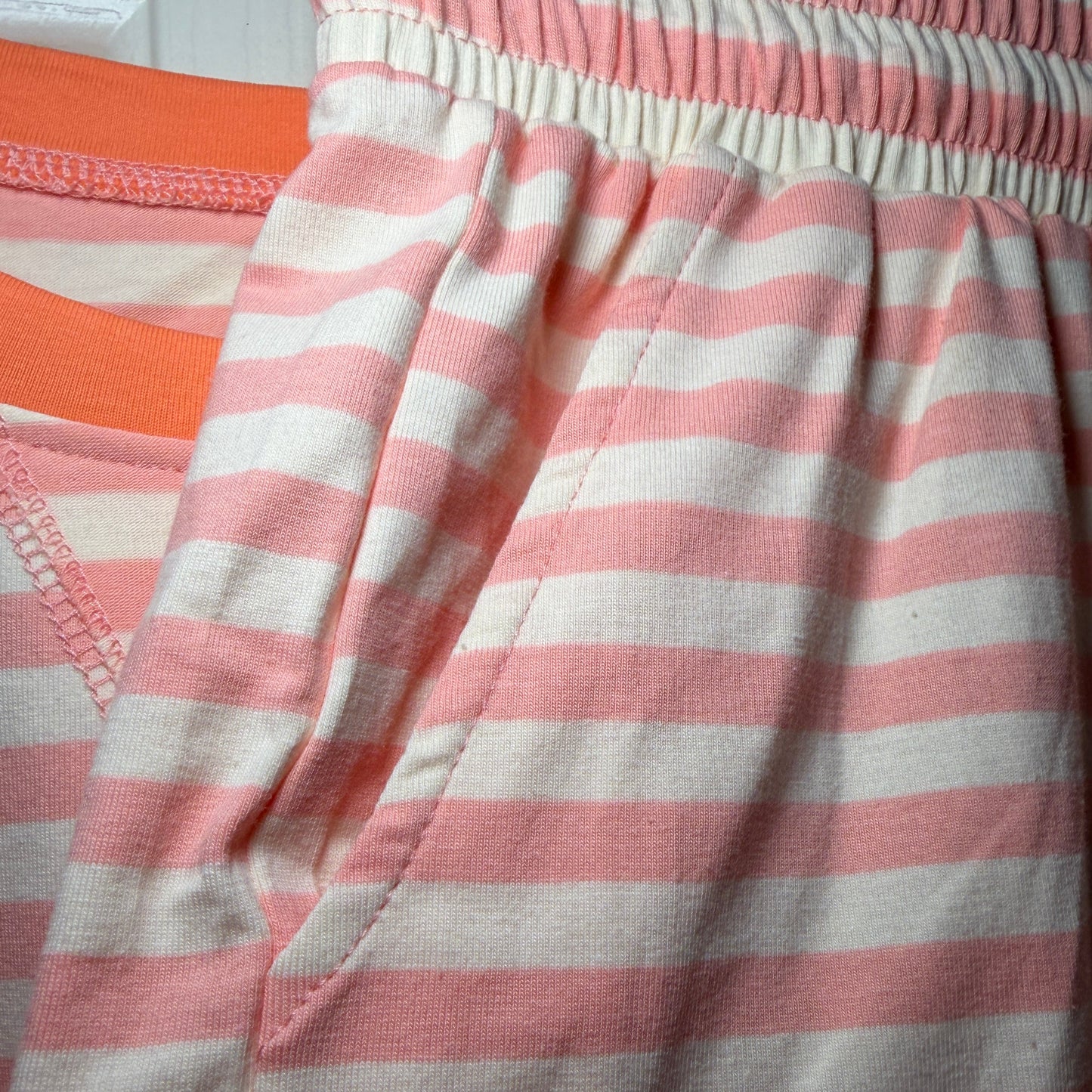 Pink and white striped fabric with a visible brand label.