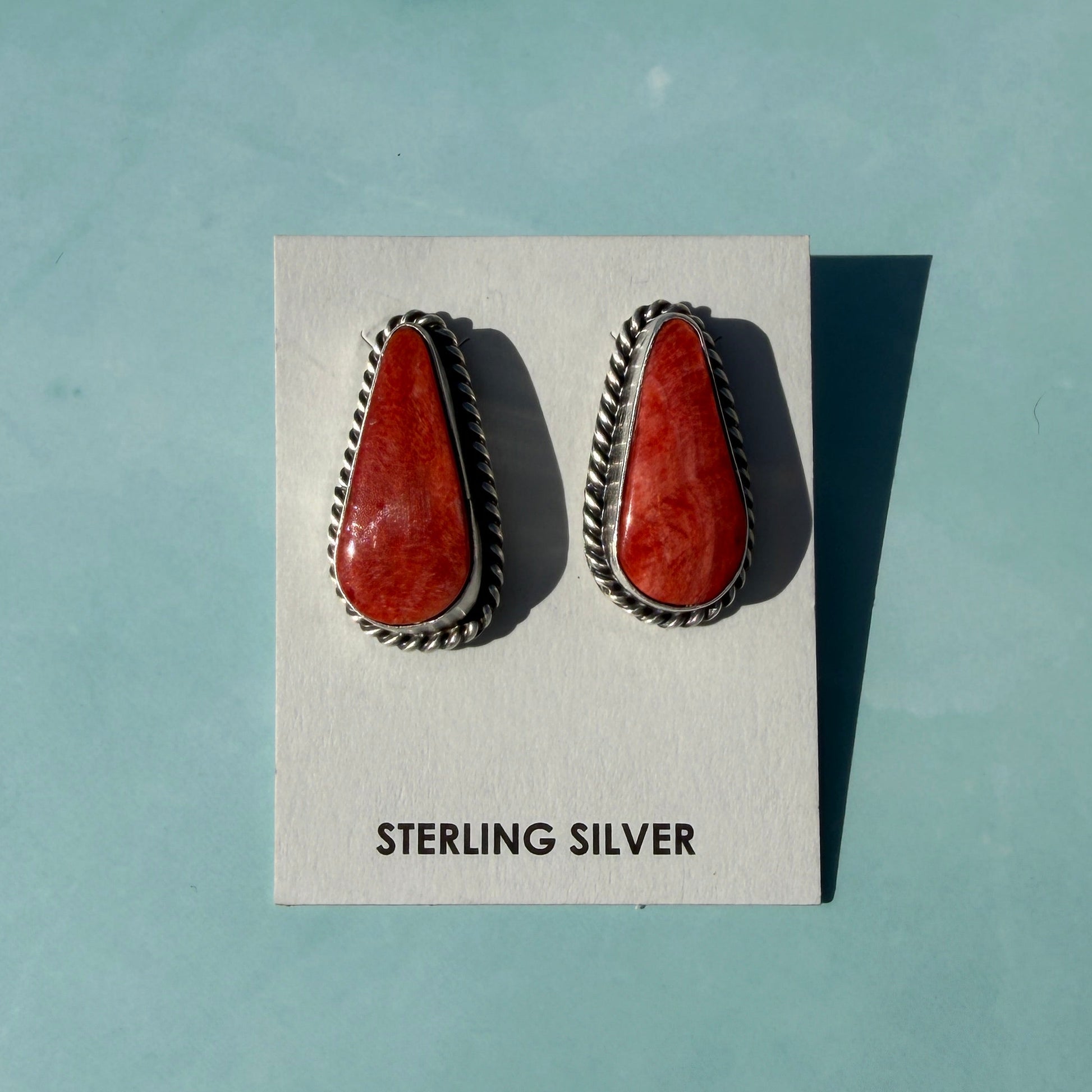 Pair of earrings on a card with 'Sterling Silver' text against a light blue background