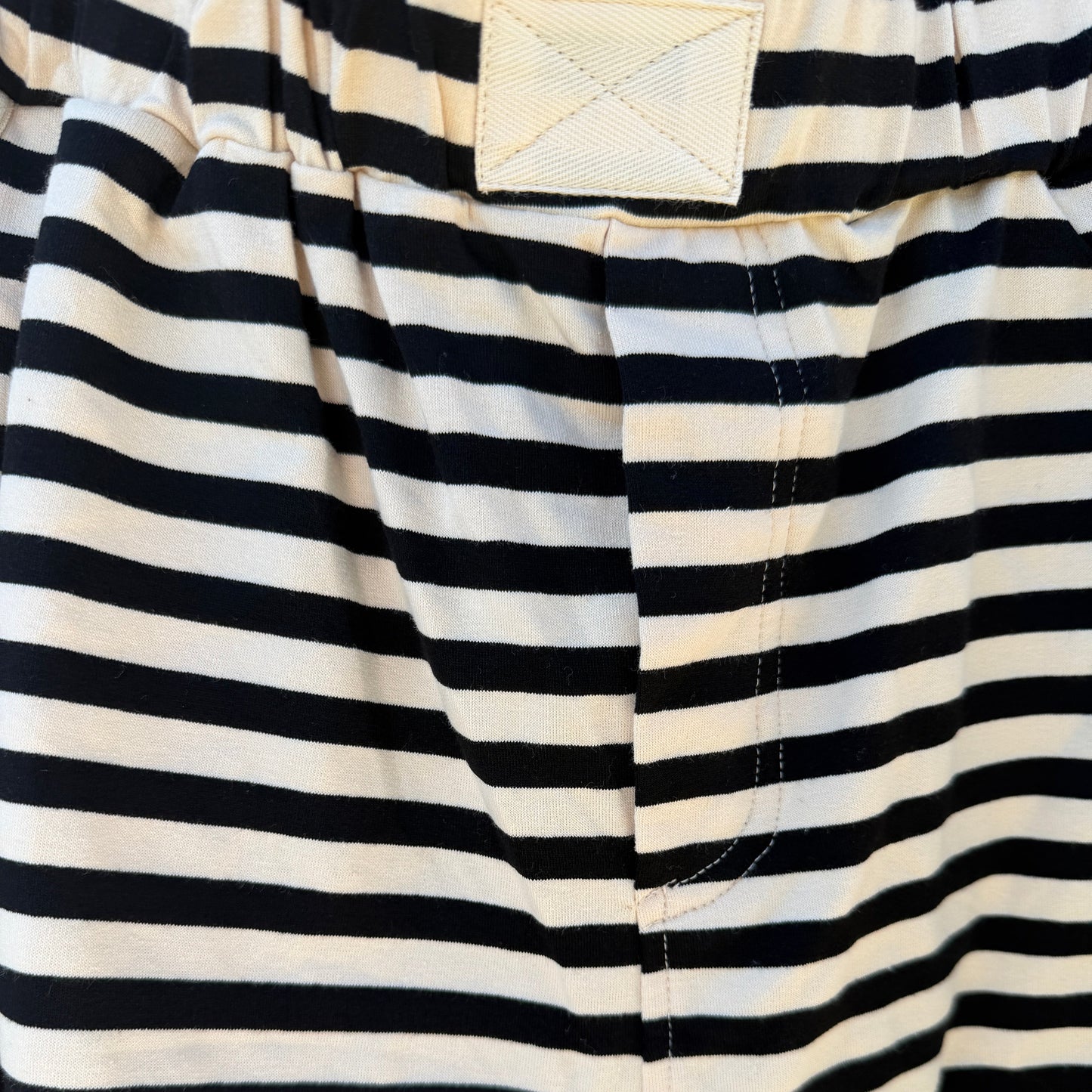 Close-up of black and white striped shorts with a pocket visible.