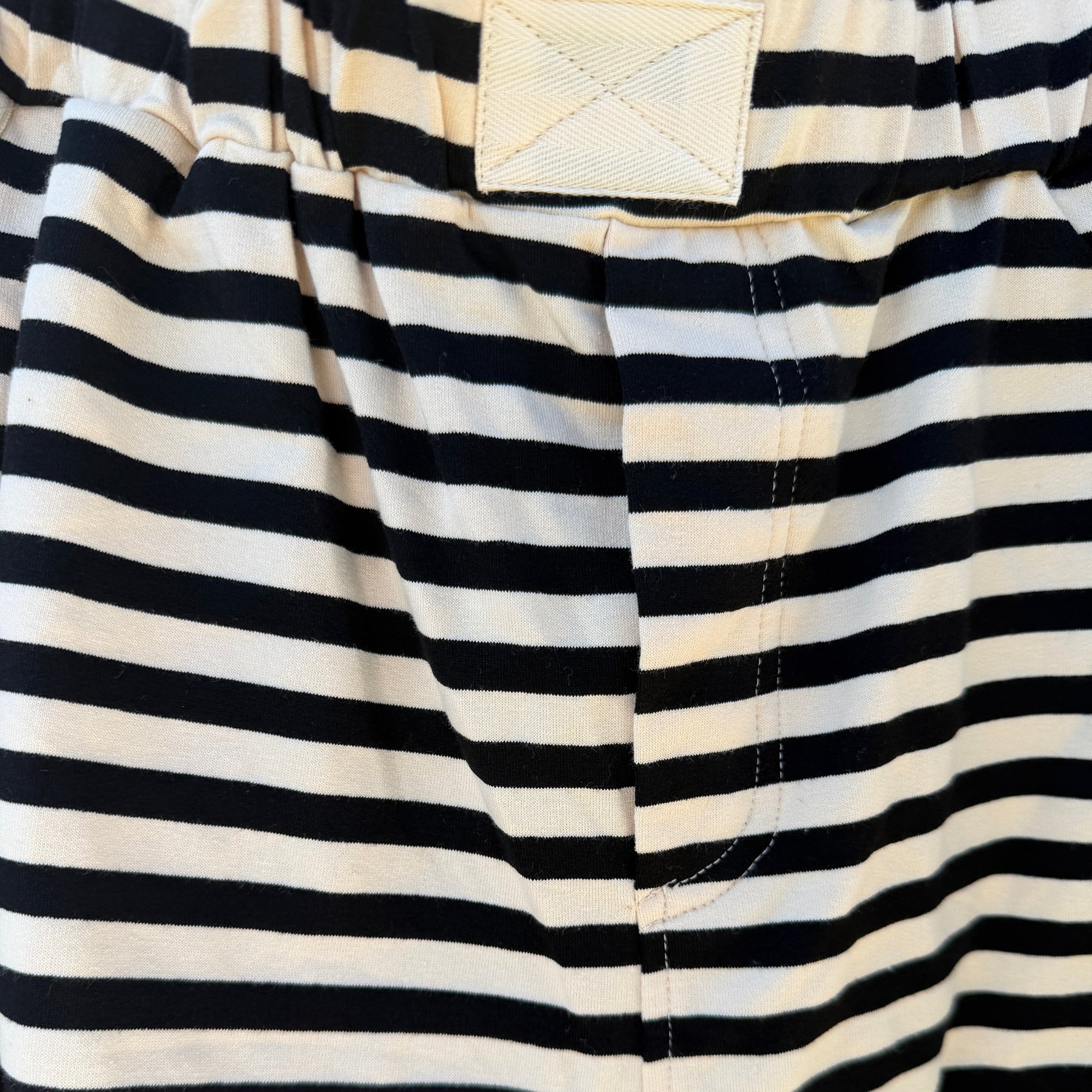 Close-up of black and white striped shorts with a pocket visible.