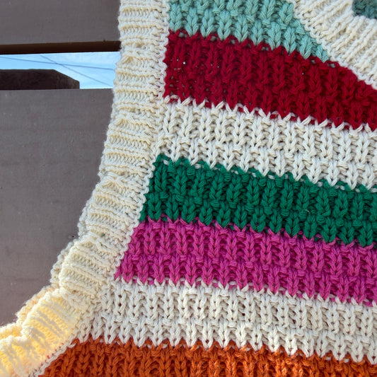 Colorful striped knitted fabric with a pattern of red, green, pink, and orange on a neutral background
