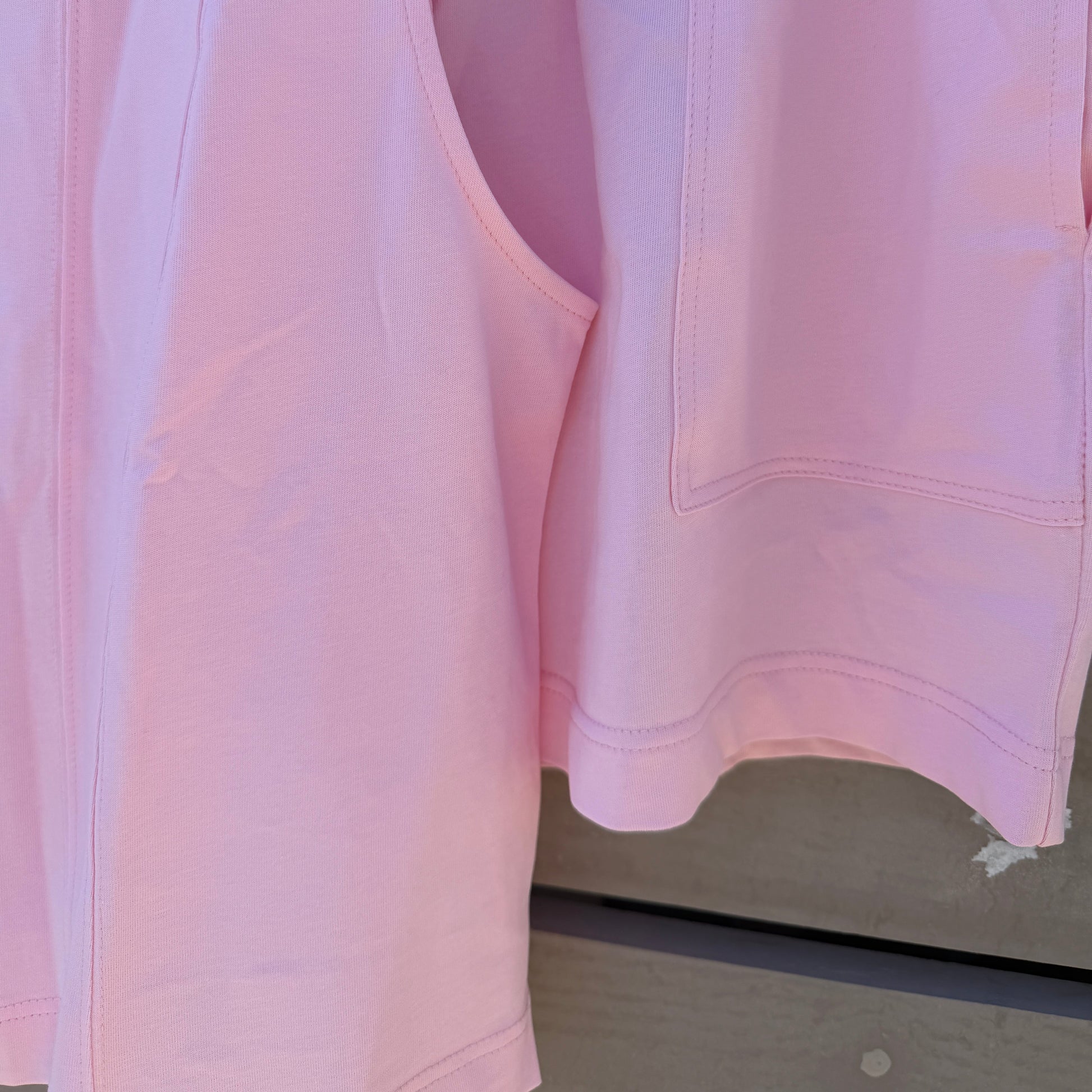 Pink shirt on a hanger with a neutral background