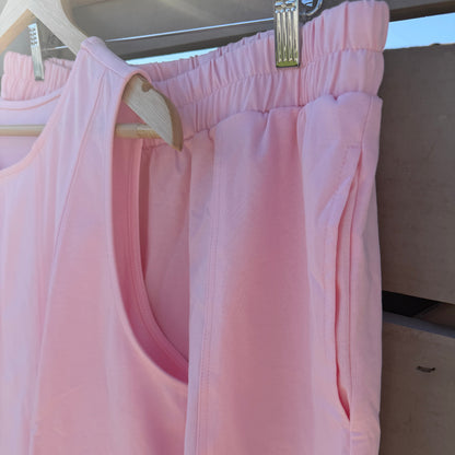 Pink shorts hanging on a rack with a neutral background