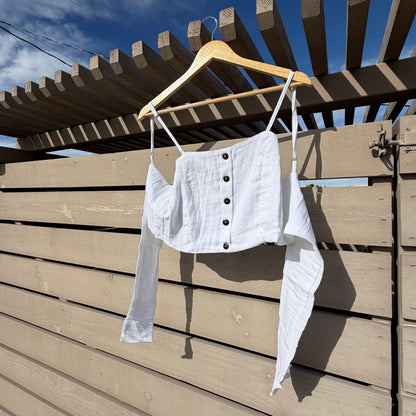 White shirt on a hanger against a wooden wall with blue sky reflection