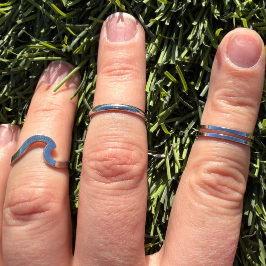 Hand with multiple rings on fingers placed on grass