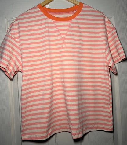 Pink and white striped shirt on a hanger against a gray background