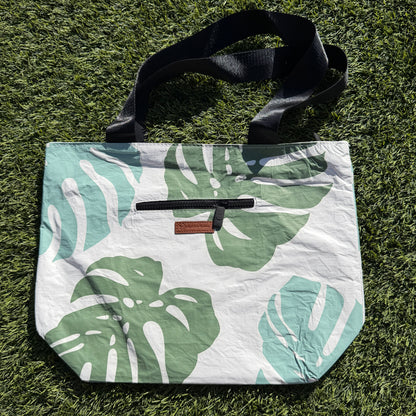 Floral-patterned bag with a strap on grass