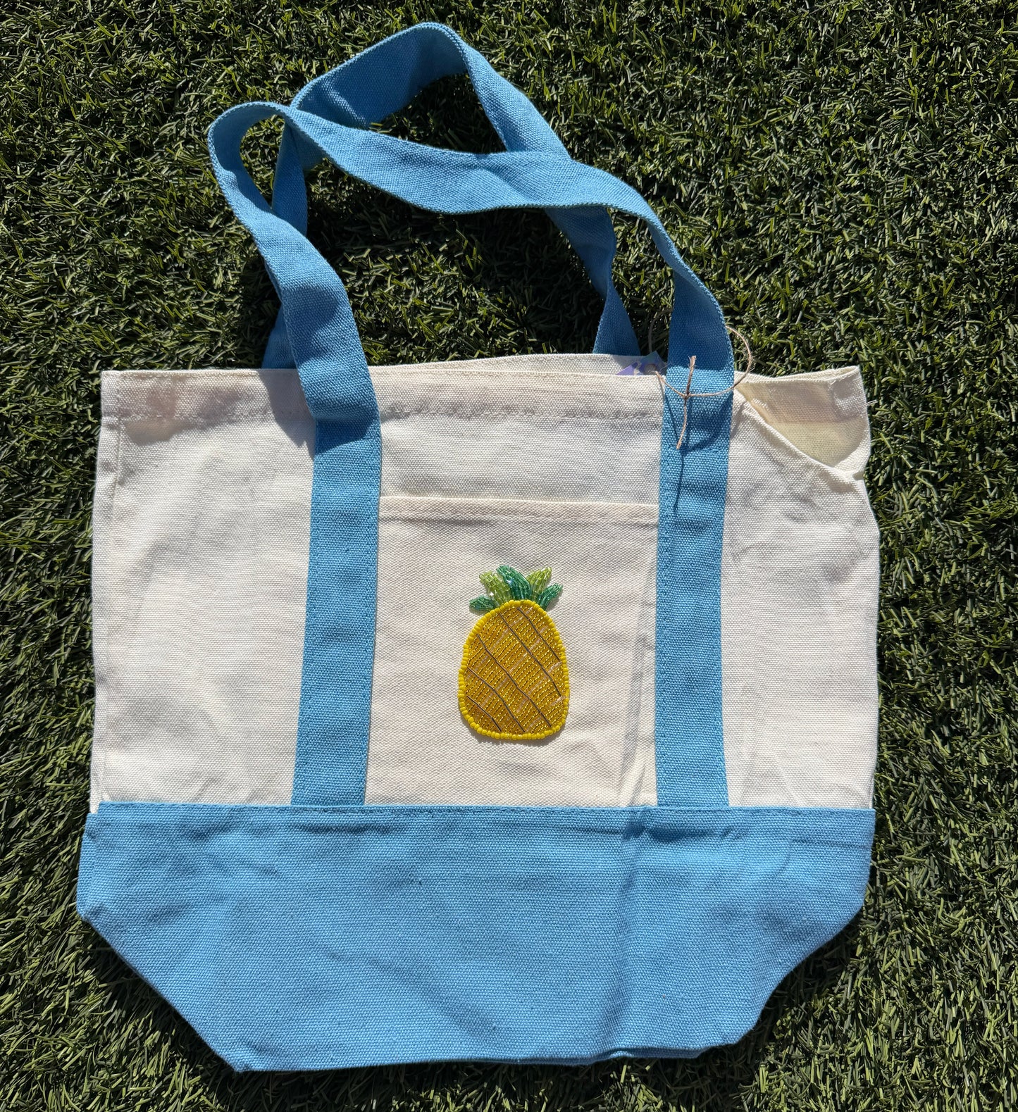 Tote bag with pineapple design on grass