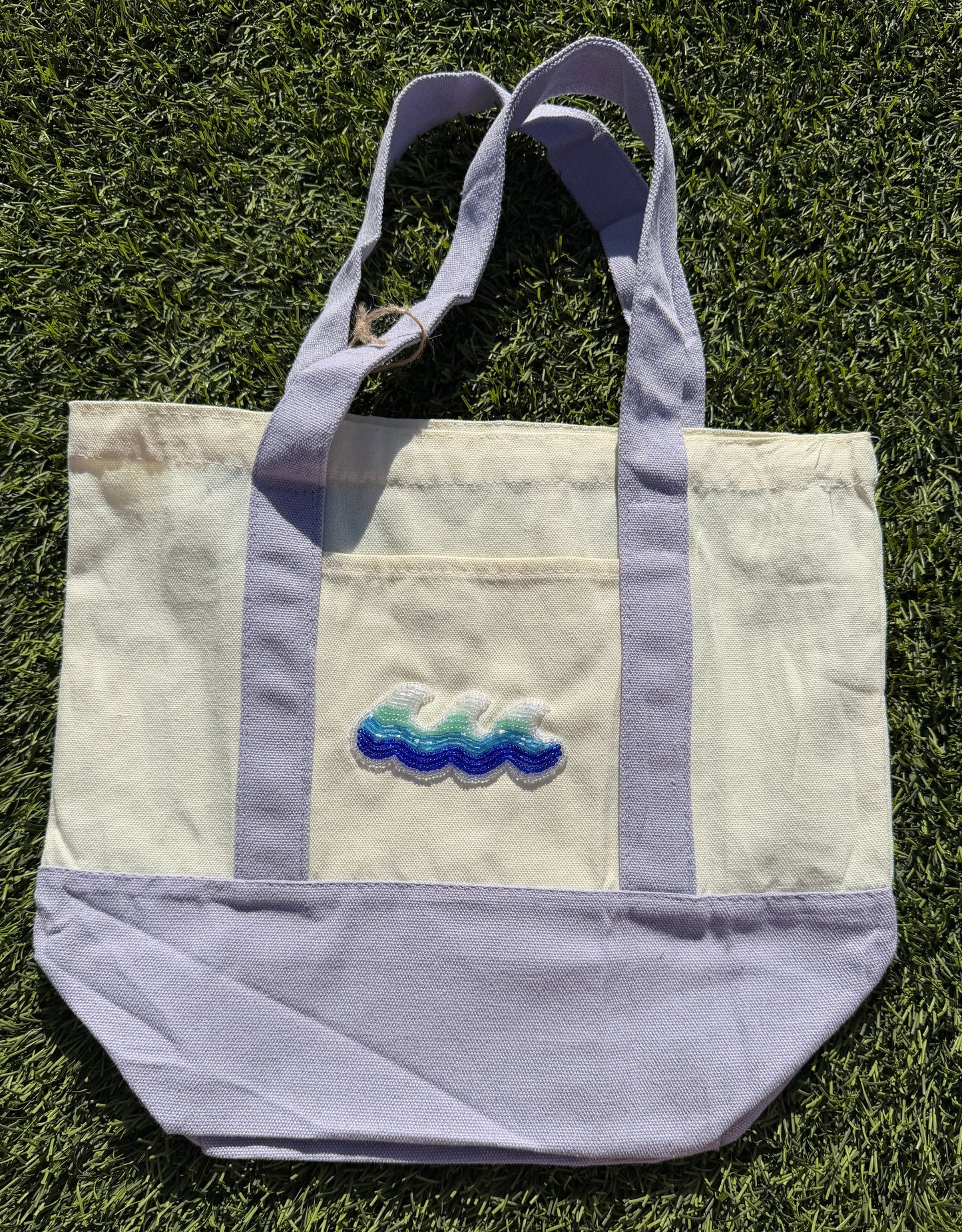 Tote bag with embroidered design on grass
