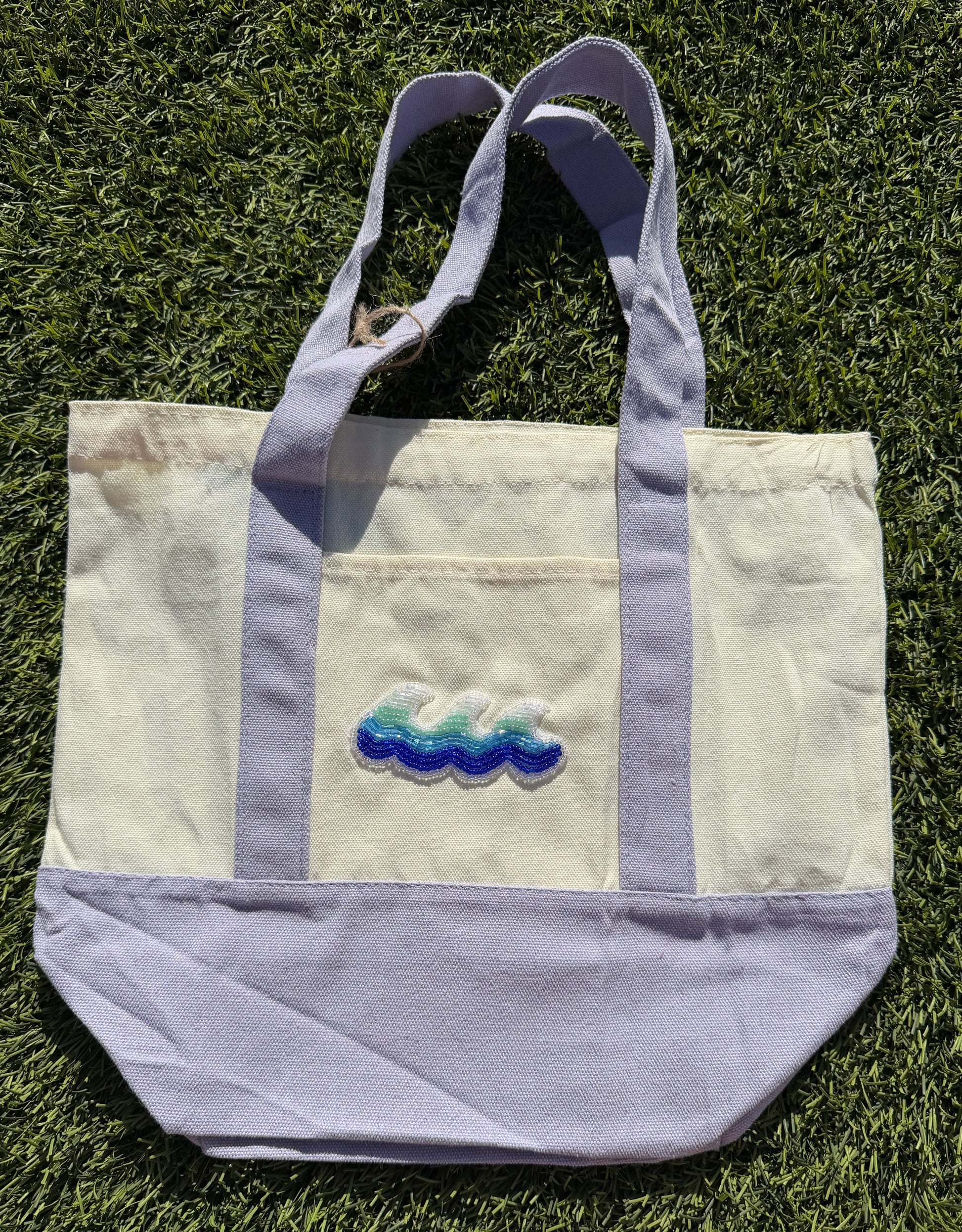 Tote bag with embroidered design on grass