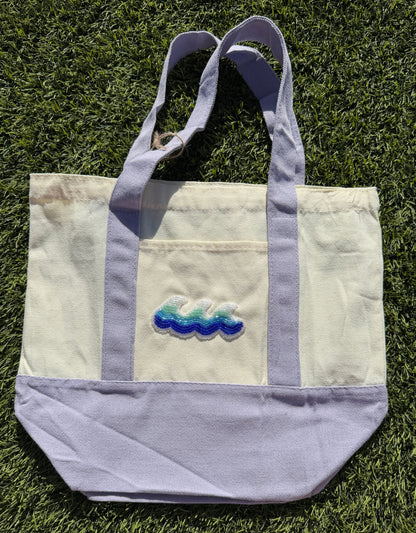 Tote bag with embroidered design on grass