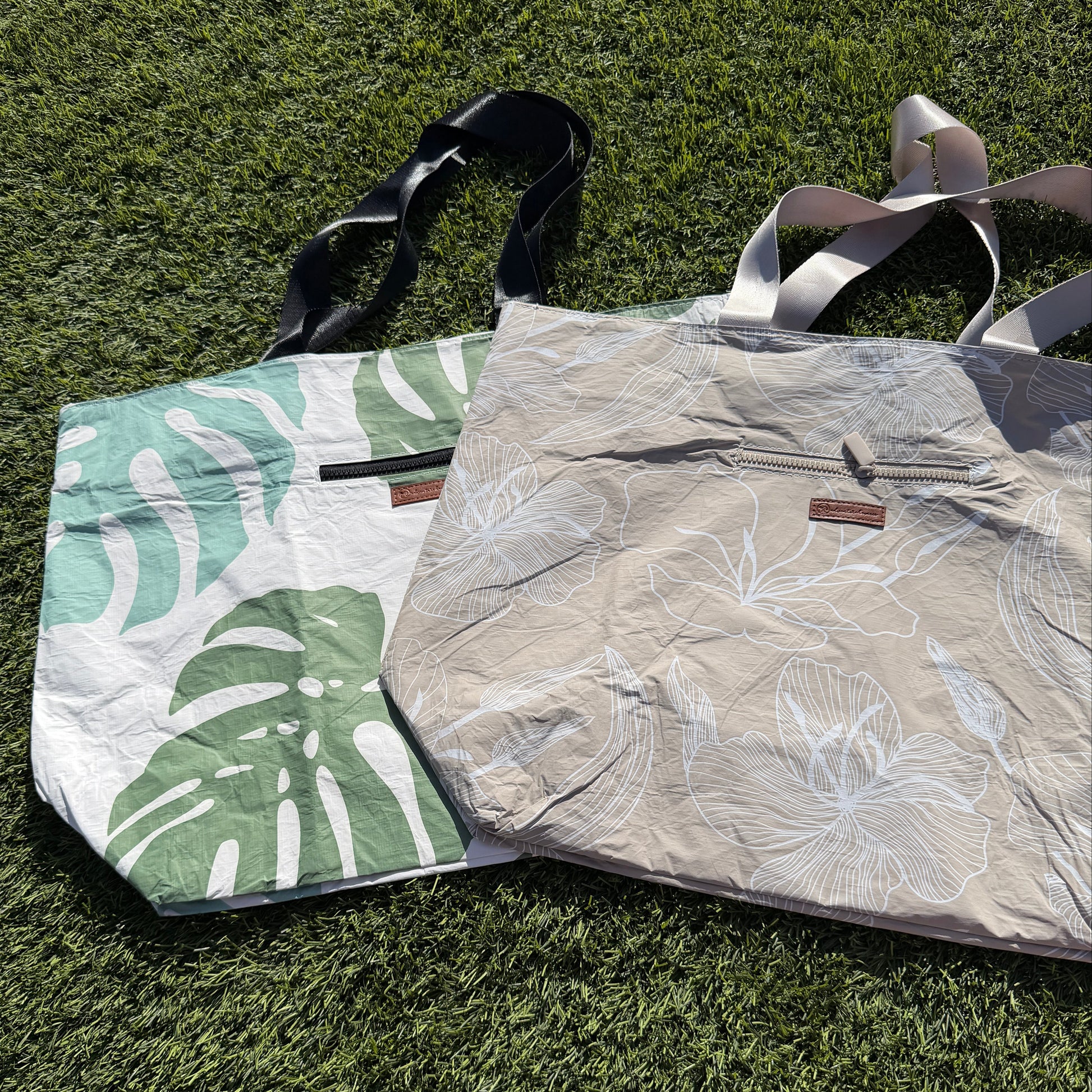Two bags on grass, one with a leaf pattern and the other plain.