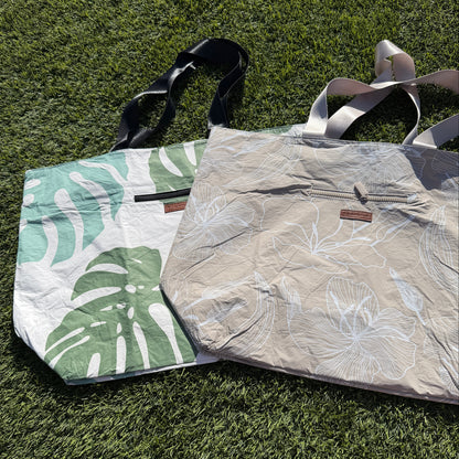 Two bags on grass, one with a leaf pattern and the other plain.