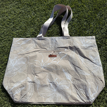 Floral-patterned tote bag on a grassy background