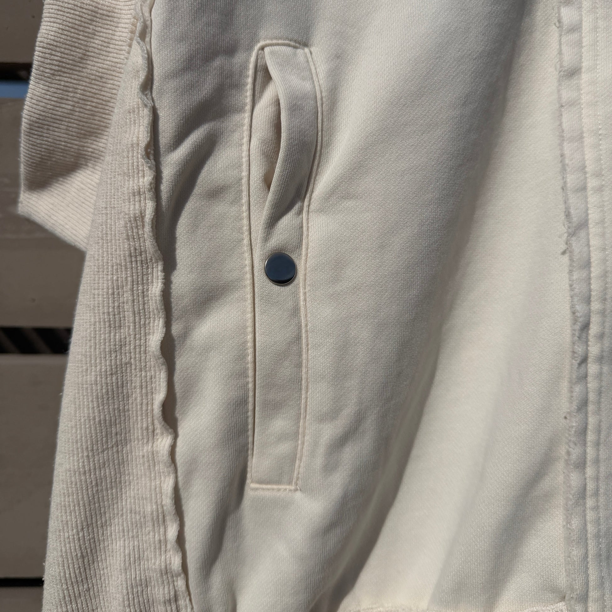 Close-up of a white jacket with a button on a blurred background